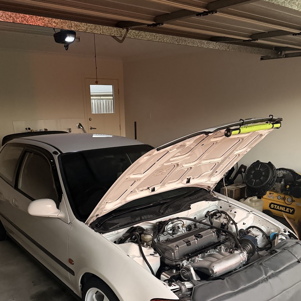 A Honda Civic with the bonnet up, mid-build